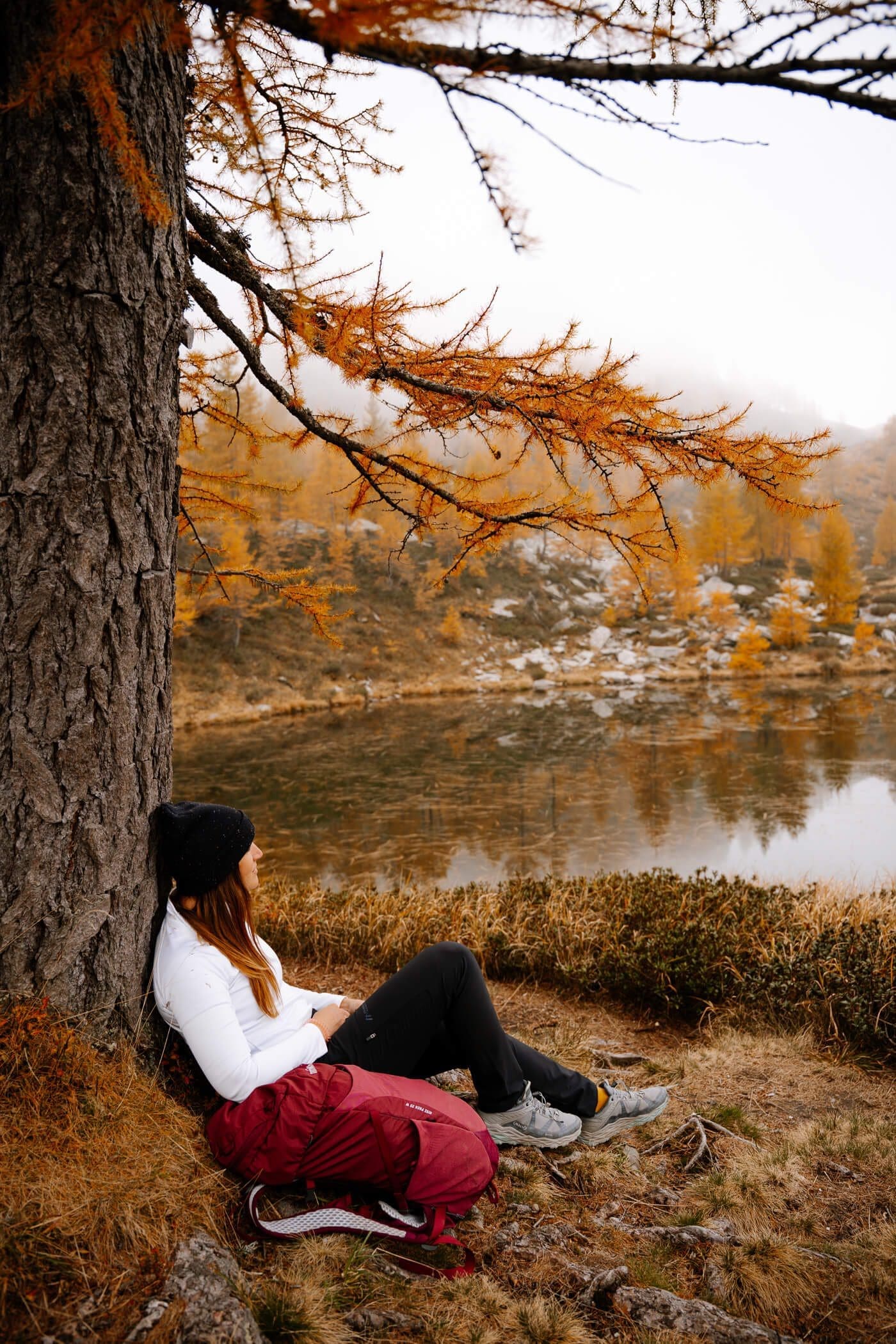 2025-10-16-Lago-Salei149 Person sitzt am Baum am See