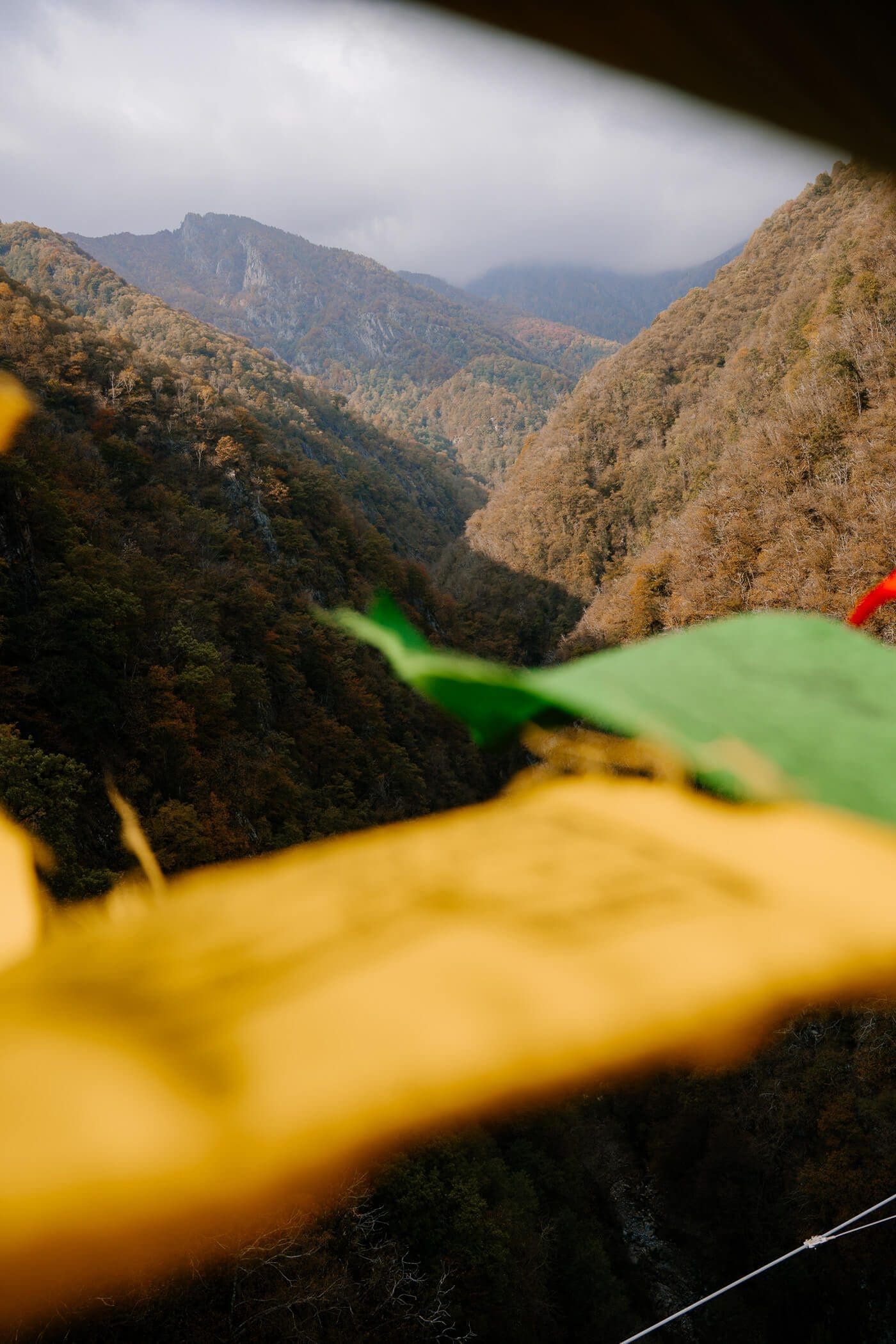 2025-10-17-Bellinzona-Tibet-Brücke38 Blick ins Tal mit Flaggen von Brücke