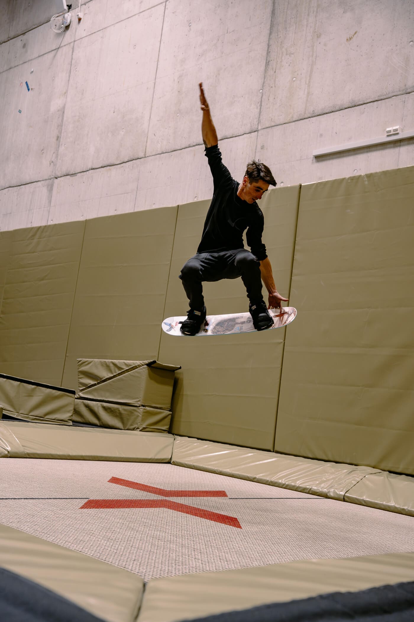 mit dem Snowboard auf dem Trampolin